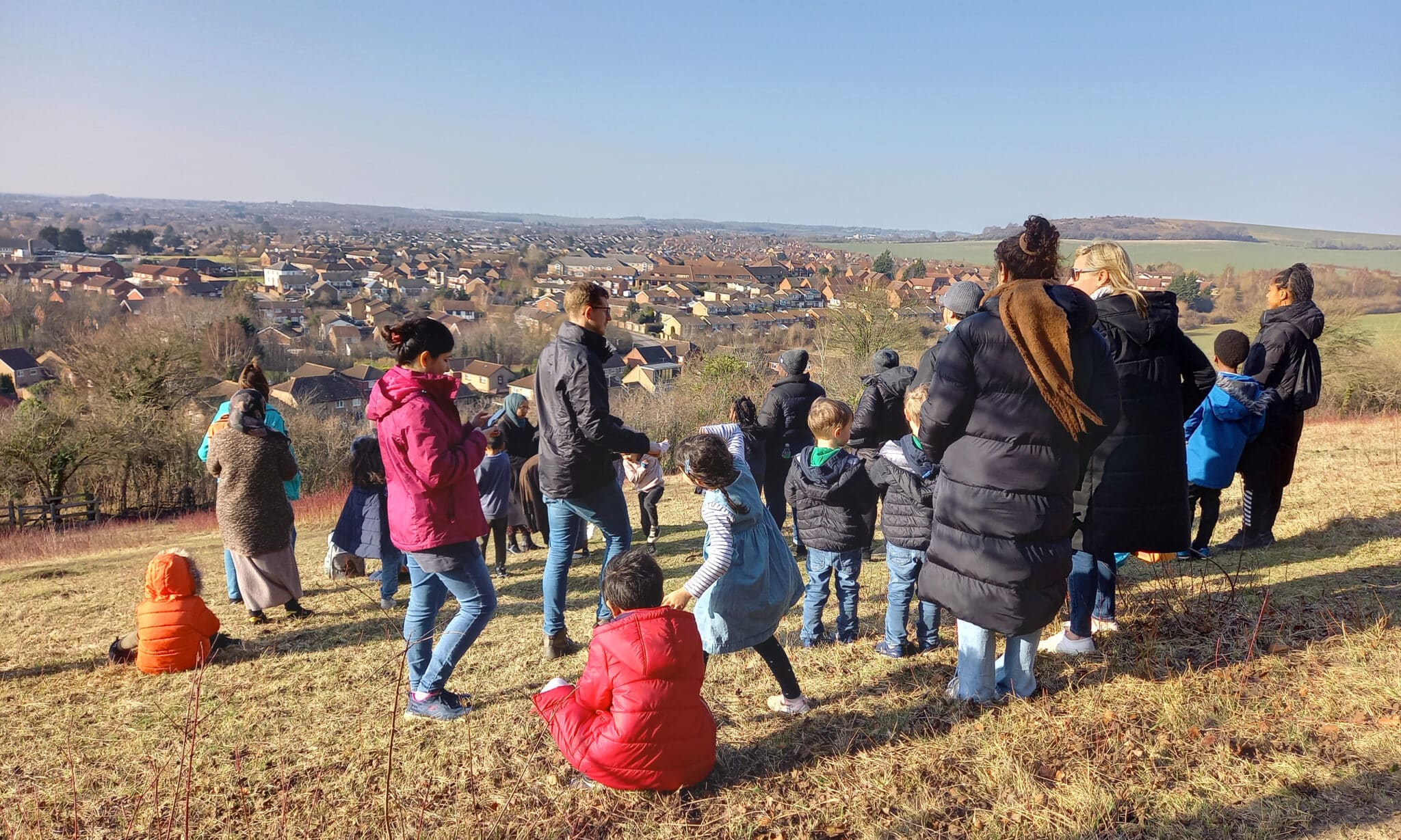 people standing on hill with blue sky behind